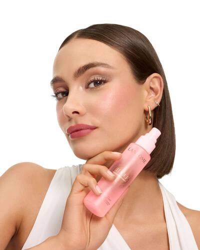 Donna con il caschetto liscio che tiene la nebbia di Lancome Idole.