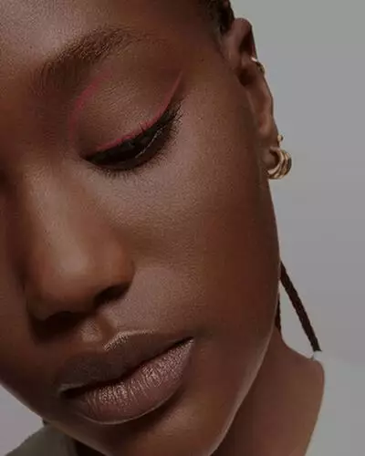 Primo piano di una modella con una linea netta e sottile di eyeliner rosa.