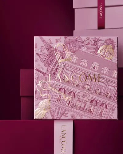 Immagine del cofanetto regalo Lancome Natale rosa davanti a una composizione di cofanetti rosa e rosso intenso, su sfondo rosso intenso.