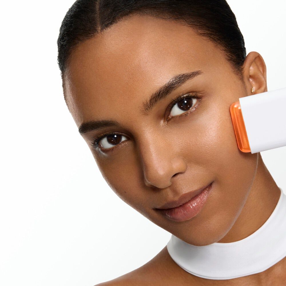 Model applying the UV EXPERT SUPRA SCREEN INVISIBLE SUN STICK SPF 50 at her face.