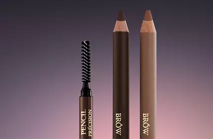 Three eyebrow pencils are displayed against a gradient background, featuring a spoolie brush on the left, with two brown pencils on the right.