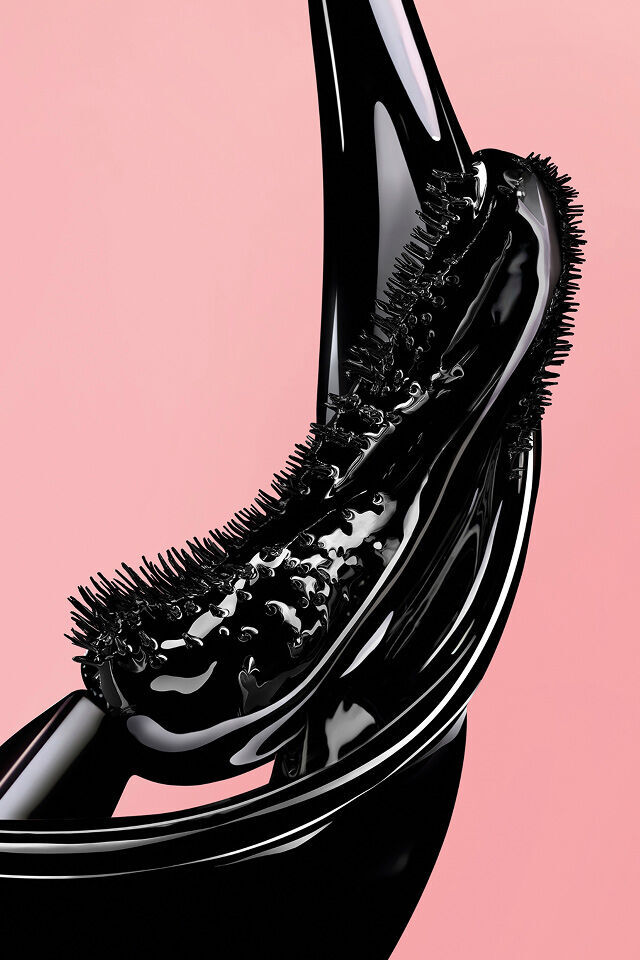 Scovolino per mascara nero con texture liquida lucida su sfondo rosa.