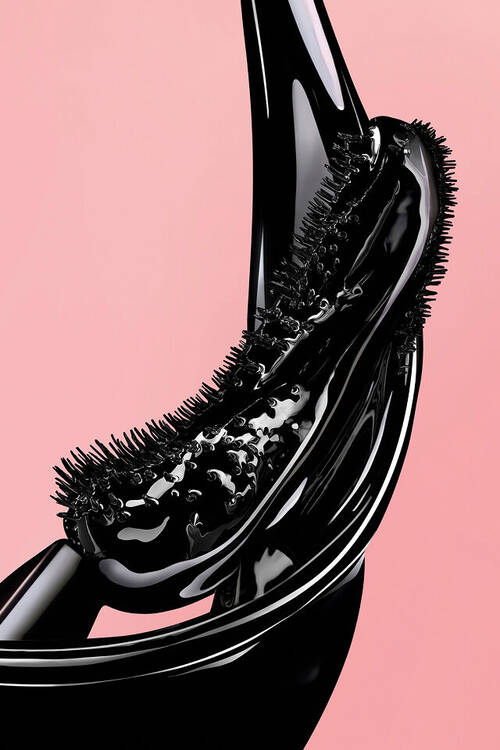 Scovolino per mascara nero con texture liquida lucida su sfondo rosa.