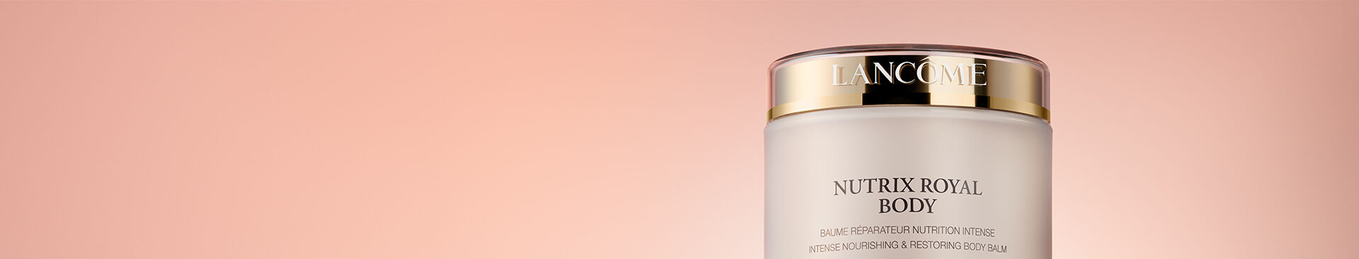 A close-up of a jar of Lancome Nutrix Royal Body cream, featuring elegant packaging with a gold lid against a soft pink background.