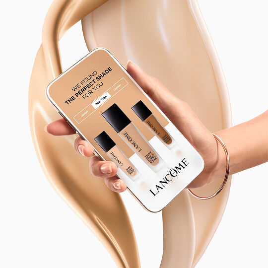 Smartphone che mostra lo strumento Lancome per trovare la tonalita del fondotinta su uno sfondo di texture liquida.