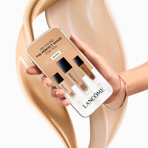 Smartphone che mostra lo strumento Lancome per trovare la tonalita del fondotinta su uno sfondo di texture liquida.