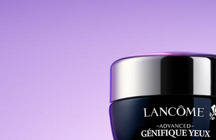 Two jars of Lancome skincare products on a purple background. The jars are labeled "Advanced Genifique" and "Renergie Multi-Lift."