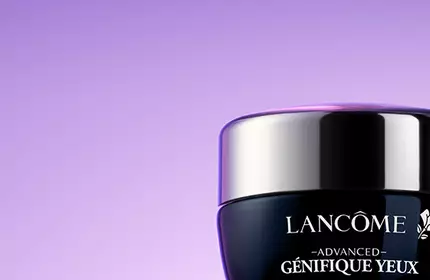 Two jars of Lancome skincare products on a purple background. The jars are labeled "Advanced Genifique" and "Renergie Multi-Lift."