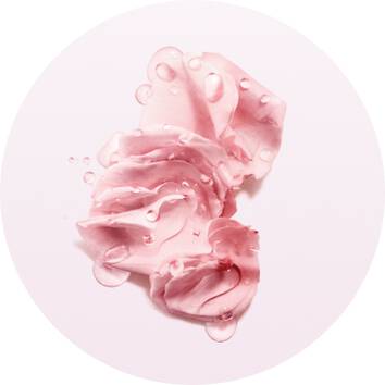 Crema rosa con gocce d'acqua su sfondo bianco, evocando freschezza e idratazione.