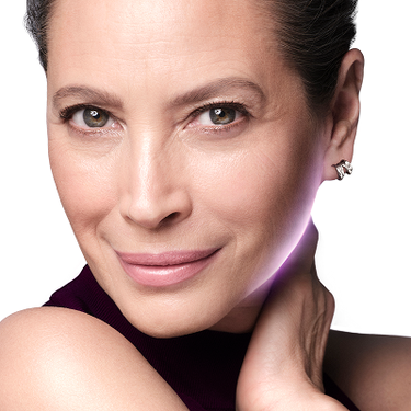 Primer plano de Christy Turlington con un maquillaje natural y una piel luminosa y radiante.