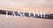 Immagine con il logo di Lancome su uno sfondo di un paesaggio acquatico al tramonto.