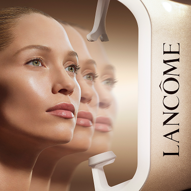 Innovazione Beauty Tech Lancome: modella con pelle radiosa davanti a un dispositivo di analisi della pelle professionale su sfondo dorato.