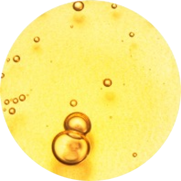 Immagine di bolle d'aria trasparenti su uno sfondo giallo dorato, creando un effetto visivo luminoso e vibrante.