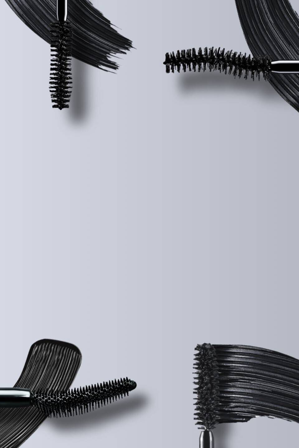 Immagine che mostra diversi applicatori di mascara e un prodotto cosmetico nero su sfondo grigio.