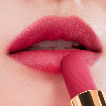 Labbra rosa opache con rossetto applicato, evidenziando luminosità e texture.